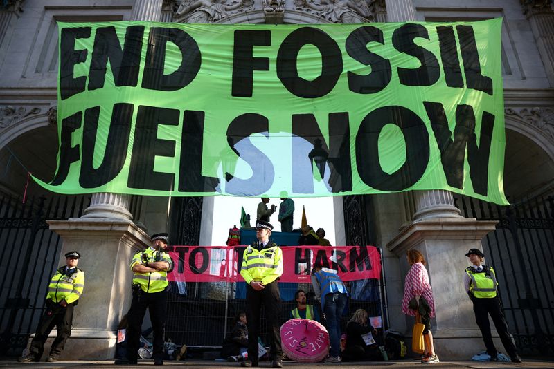 © Reuters. FILE PHOTO: Activists from the Extinction Rebellion drape a banner across Marble Arch as part of a protest in central London, Britain, April 16, 2022. REUTERS/Henry Nicholls/File Photo