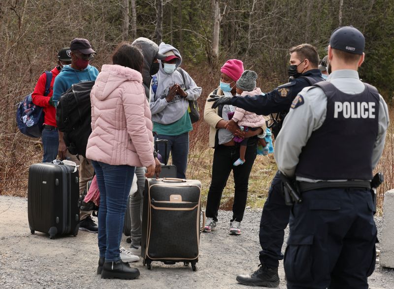 &copy; Reuters. Asylum seekers talk to a police officer as they cross into Canada from the U.S. border near a checkpoint on Roxham Road near Hemmingford, Quebec, Canada April 24, 2022. Picture taken April 24, 2022. REUTERS/Christinne Muschi