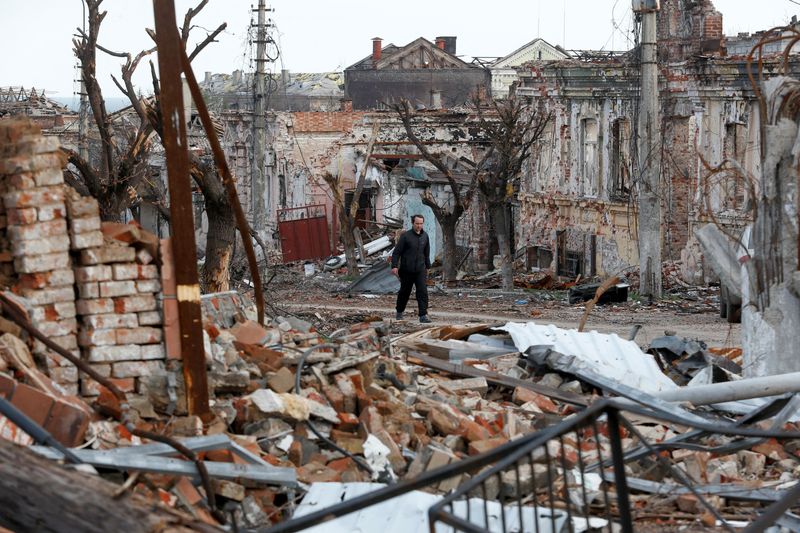 &copy; Reuters. رجل يسير بالقرب من المباني المتضررة في ماريوبول بأوكرانيا يوم 22 أبريل نيسان. تصوير: ألكسندر ارموشينكو - رويترز.