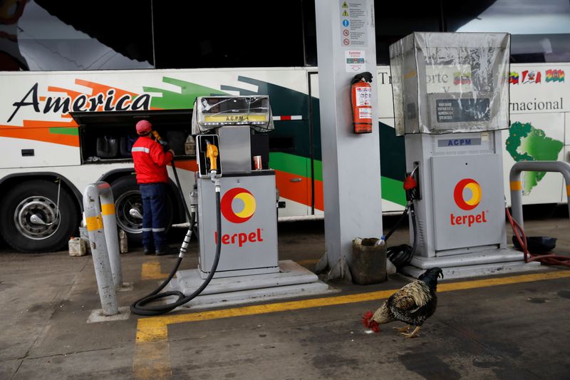 &copy; Reuters. FILE PHOTO: A gas station worker pumps fuel into a Rutas de America bus as a chicken looks for food, near Pamplona, Colombia, November 8, 2017. REUTERS/Carlos Garcia Rawlins