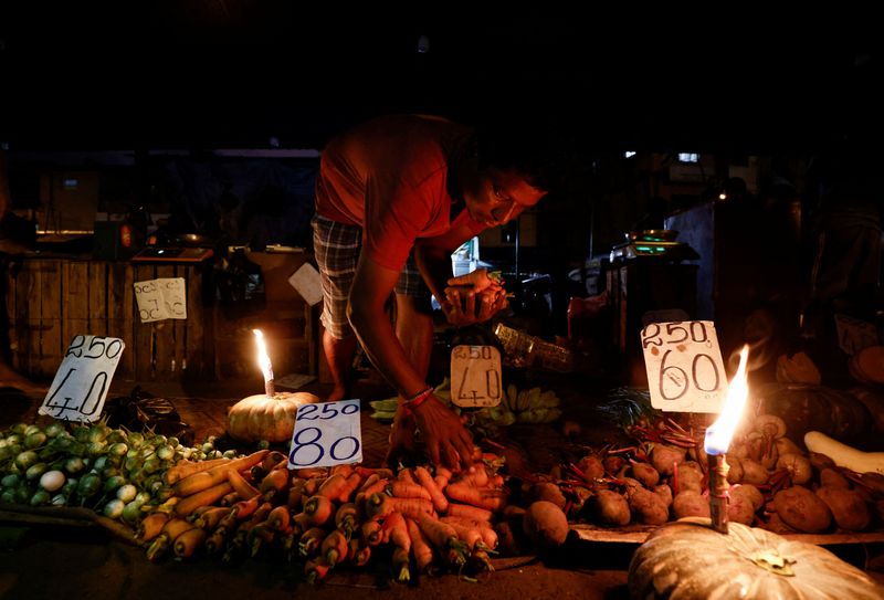 &copy; Reuters. FILE PHOTO: A vendor prepares a vegetables bag for a customer at the main market as the generator was broken, amid the country's economic crisis in Colombo, Sri Lanka, April 20, 2022. REUTERS/Dinuka Liyanawatte
