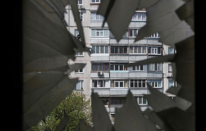 &copy; Reuters. Un bloque de apartamentos visto a través de la ventana destrozada de un edificio residencial quemado durante la invasión rusa de Ucrania, en Járkov, Ucrania, el 25 de abril de 2022. REUTERS/Ricardo Moraes     