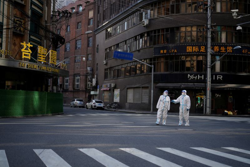 &copy; Reuters. FILE PHOTO: Workers in protective suits keep watch on a street during a lockdown, amid the coronavirus disease (COVID-19) pandemic, in Shanghai, China, April 16, 2022. REUTERS/Aly Song