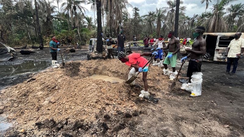 &copy; Reuters. A person digs a grave for the mass burial of victims of the explosion at the illegal bunkering site in Imo state, Nigeria April 26, 2022. REUTERS/Tife Owolabi