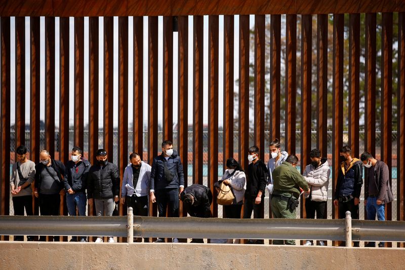 © Reuters. FOTO DE ARCHIVO: Inmigrantes en busca de asilo son detenidos en la frontera de EEUU, 30 de marzo de 2022. REUTERS/Jose Luis Gonzalez/File Photo