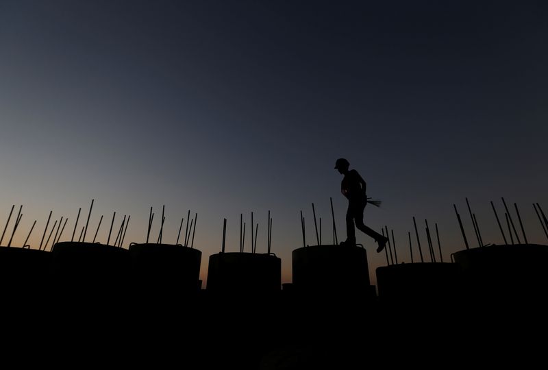 &copy; Reuters. FILE PHOTO: A worker walks on top of seawall concrete at the New Priok Port in Jakarta, Indonesia July 26, 2017. REUTERS/Beawiharta