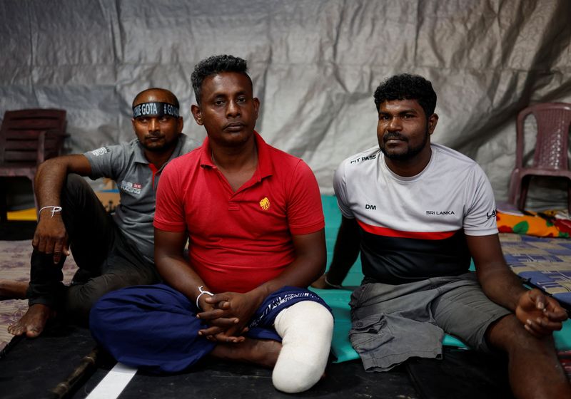 &copy; Reuters. Sri Lankan military veterans H.M.S Mahindasiri, (C) and Uditha Roshan (R) sit at a protest site near the Presidential Secretariat in Colombo, Sri Lanka, April 25, 2022. Picture taken April 25, 2022. REUTERS/Navesh Chitrakar