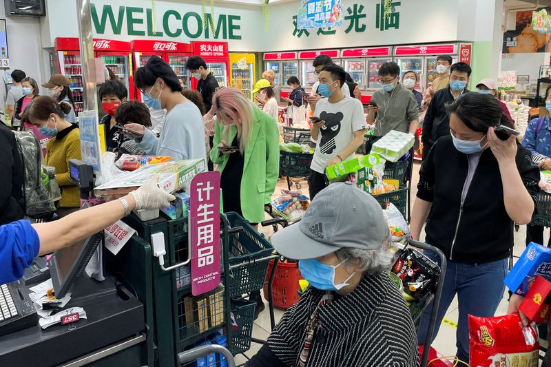 &copy; Reuters. FILE PHOTO: People wearing face masks wait in lines to pay for their products at a supermarket following the coronavirus disease (COVID-19) outbreak in Chaoyang district of Beijing, China April 24, 2022. REUTERS/Carlos Garcia Rawlins
