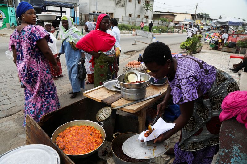 &copy; Reuters. A woman sells plantains fried in crude palm oil, on a street in Abidjan, Ivory coast April 12, 2022. Picture taken April 12, 2022. REUTERS/Luc Gnago