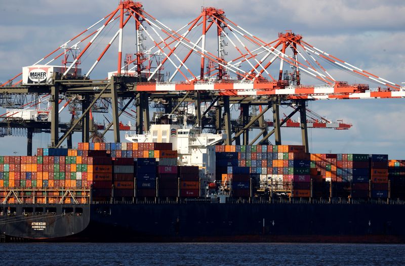 &copy; Reuters. FILE PHOTO: A ship stacked with shipping containers is unloaded on a pier at Port Newark, New Jersey, U.S., November 19, 2021. REUTERS/Mike Segar/File Photo