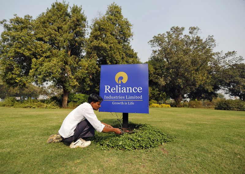 &copy; Reuters. FILE PHOTO: A gardener works next to a board of Reliance Industries Ltd at Gandhinagar in Gujarat, India, January 19, 2016. REUTERS/Amit Dave