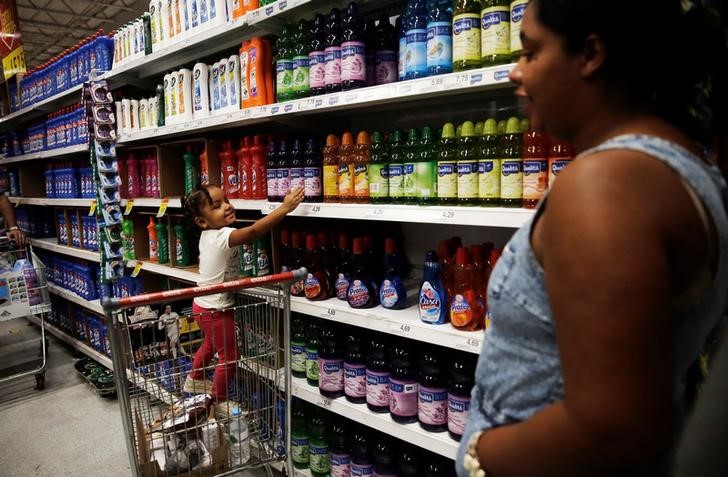 &copy; Reuters. Criança está em um carrinho de compras enquanto aponta produtos de limpeza ao lado de sua mãe em um supermercado em São Paulo, Brasil 24 de novembro de 2016. REUTERS/Nacho Doce