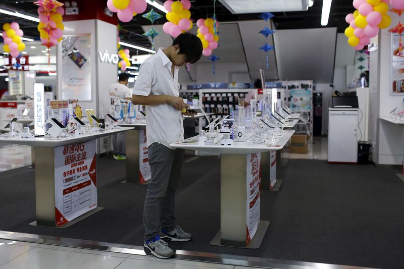 &copy; Reuters. FILE PHOTO: A customer look at a mobile phone on display at an electronics market in Shanghai, China, June 24, 2015. REUTERS/Aly Song