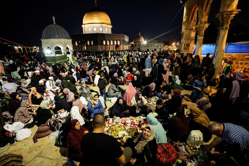 &copy; Reuters. فلسطينيون يأكلون قبل بدء صلاة التراويح في ليلة القدر في المسجد الأقصى في القدس يوم الأربعاء. تصوير: عمار عوض - رويترز.
