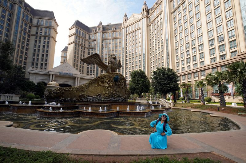 &copy; Reuters. FILE PHOTO: A visitor poses for pictures at Castle Hotel on the man-made Ocean Flower Island, an integrated resort development by China Evergrande Group, in Danzhou, Hainan province, China January 7, 2022. REUTERS/Aly Song