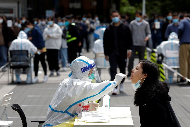 © Reuters. A medical worker in a protective suit collects a swab sample from a resident at a makeshift nucleic acid testing site amid the coronavirus disease (COVID-19) outbreak in Beijing, China April 28, 2022. REUTERS/Carlos Garcia Rawlins