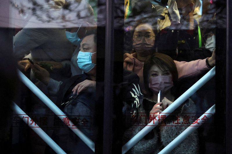 &copy; Reuters. FILE PHOTO: Commuters wearing face masks following the coronavirus disease (COVID-19) outbreak stand on a bus in the early morning, near a border checkpoint with Hebei province, in Beijing, China April 13, 2022. Picture taken April 13, 2022. REUTERS/Tings