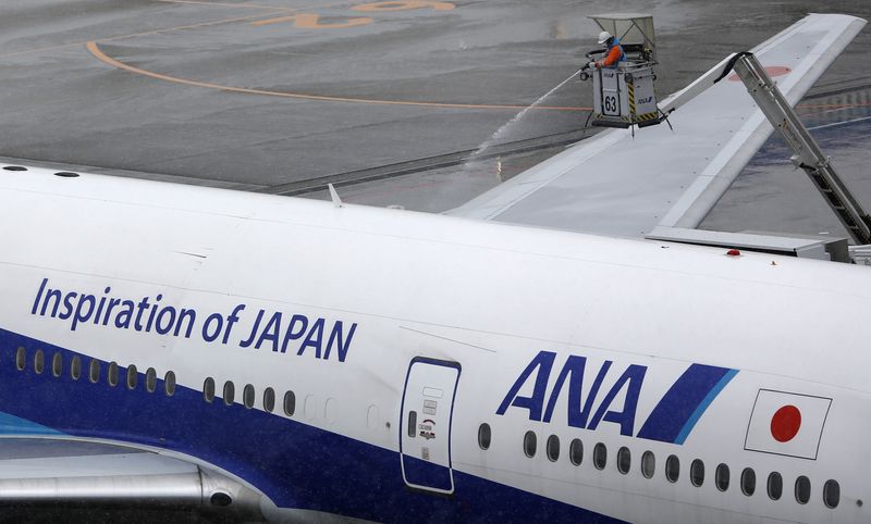&copy; Reuters. FILE PHOTO: A man works near an All Nippon Airways' (ANA) air plane parked at Haneda airport in Tokyo February 14, 2014.  REUTERS/Yuya Shino