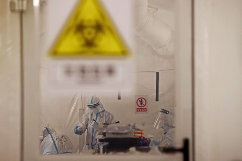 &copy; Reuters. FILE PHOTO: Workers in protective suits work inside a makeshift nucleic acid testing laboratory, following the coronavirus disease (COVID-19) outbreak in Shanghai, China April 11, 2022. Picture taken April 11, 2022. cnsphoto via REUTERS  