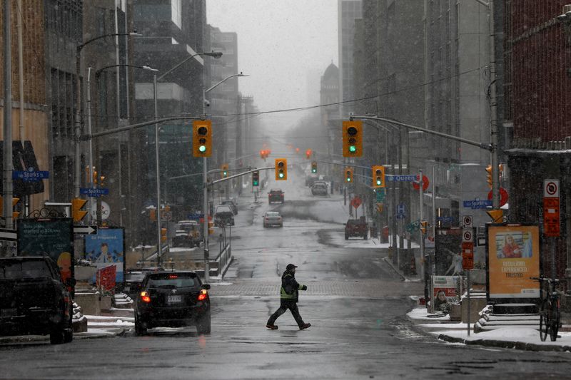 &copy; Reuters. FILE PHOTO: A pedestrian crosses a quiet downtown street as efforts continue to help slow the spread of coronavirus disease (COVID-19) in Ottawa, Ontario, Canada March 23, 2020.  REUTERS/Blair Gable/File Photo