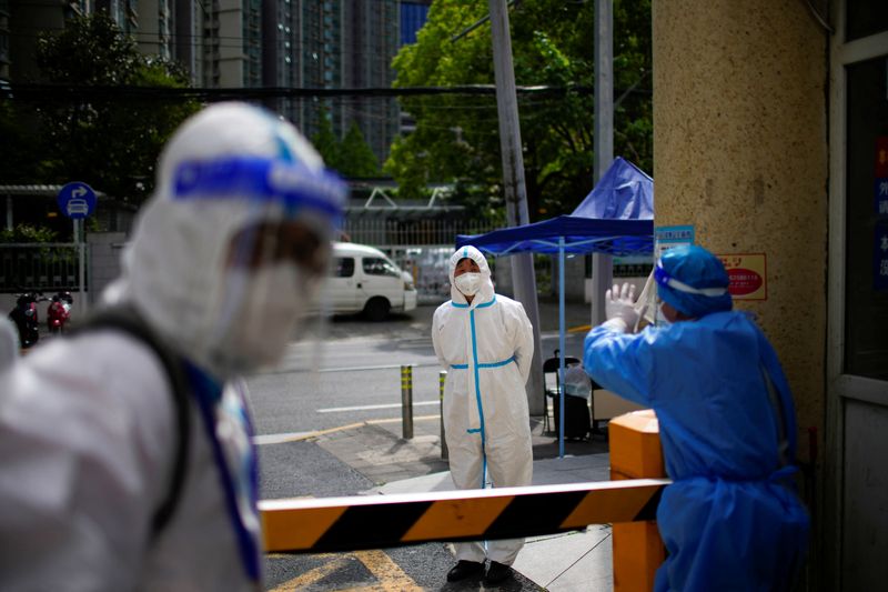 &copy; Reuters. Workers in protective suits are seen at a residential area during lockdown amid the coronavirus disease (COVID-19) pandemic, in Shanghai, China April 27, 2022. REUTERS/Aly Song