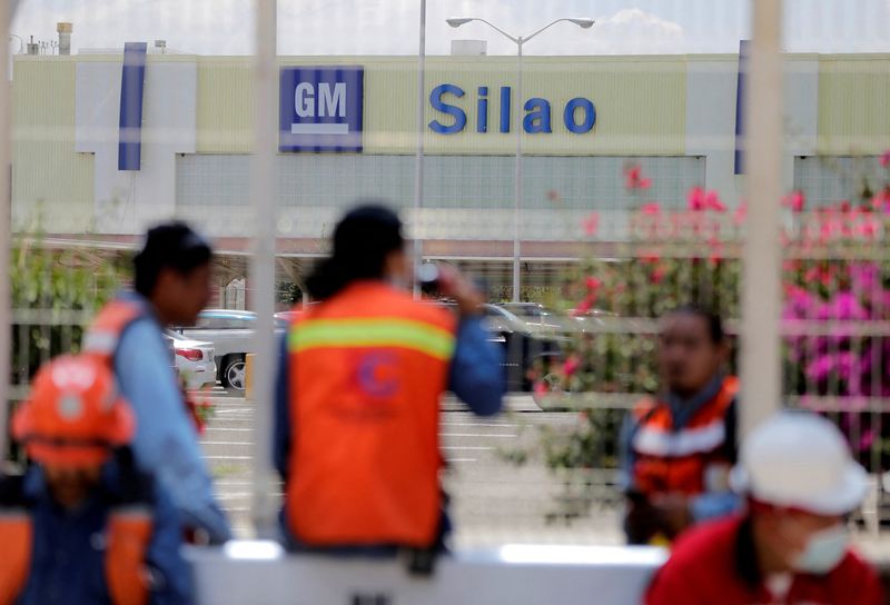 © Reuters. FILE PHOTO: Workers sit outside the General Motors plant as its employees are to vote on whether to reject or keep the collective bargaining agreement, marking the first major test of labor rules under the United States-Mexico-Canada Agreement (USMCA), in Silao, Mexico August 17, 2021.  REUTERS/Sergio Maldonado/File Photo