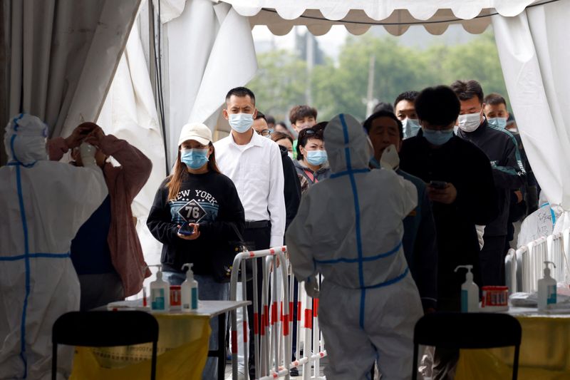 &copy; Reuters. Trabajadores médicos con trajes de protección recogen hisopos de los residentes en un sitio improvisado de pruebas de ácido nucleico en medio del brote de la enfermedad del coronavirus (COVID-19) en Pekín, China 29 de abril de 2022. REUTERS/Carlos Gar