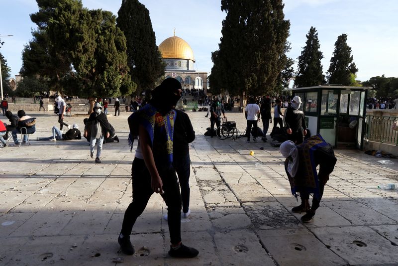 &copy; Reuters. Manifestantes palestinos caminan durante los enfrentamientos con las fuerzas de seguridad israelíes en el complejo que alberga la mezquita de Al-Aqsa, conocida por los musulmanes como Noble Santuario y por los judíos como Monte del Templo, en la Ciudad 