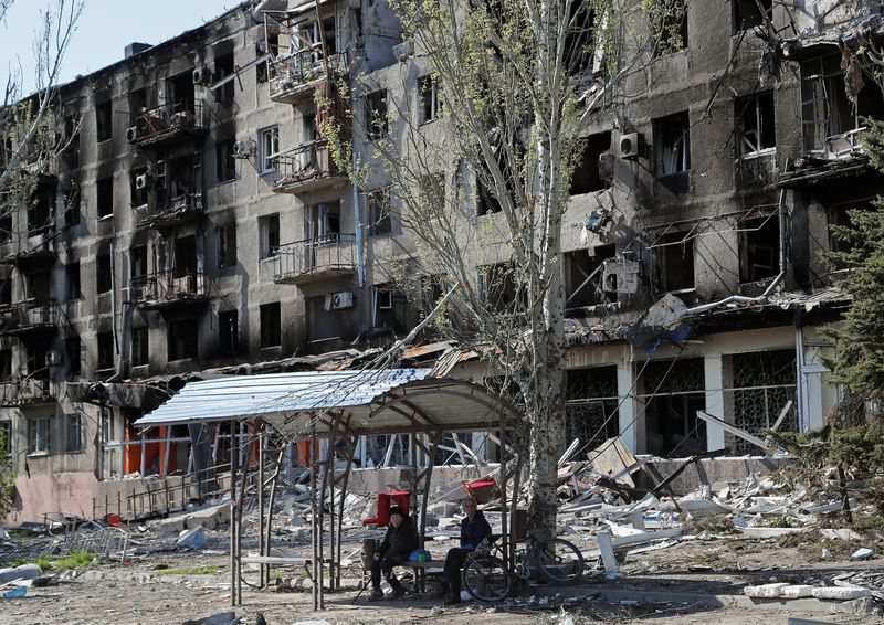 &copy; Reuters. Local residents sit on a bench near an apartment building damaged during Ukraine-Russia conflict in the southern port city of Mariupol, Ukraine April 28, 2022. REUTERS/Alexander Ermochenko