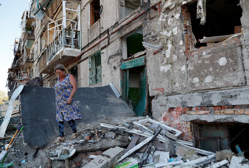 &copy; Reuters. Moradora caminha em meio a escombros do lado de fora de prédio residencial danificado em Mariupol, na Ucrânia
28/04/2022 REUTERS/Alexander Ermochenko