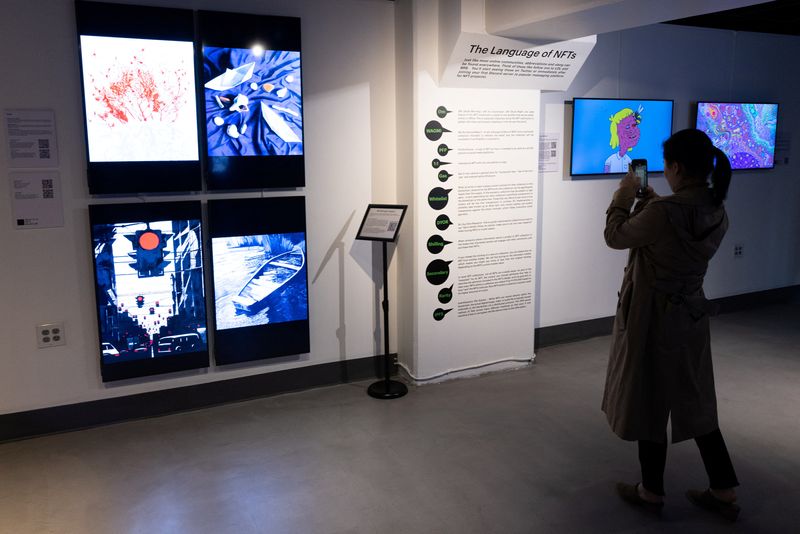 &copy; Reuters. A visitor takes pictures of signage during 'The Climate Conversation’ exhibition at Seattle NFT Museum, the first permanent blockchain-based digital art museum in the world, in Seattle, Washington, U.S., April 16, 2022.  REUTERS/Matt Mills McKnight