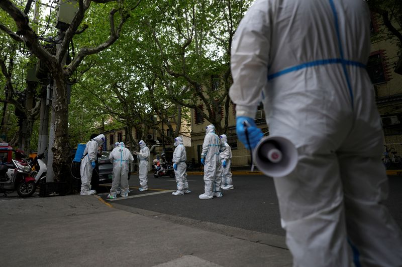 &copy; Reuters. FILE PHOTO: Workers in protective suits stand on a street during a lockdown, amid the coronavirus disease (COVID-19) pandemic, in Shanghai, China, April 16, 2022. REUTERS/Aly Song
