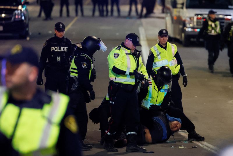 © Reuters. ضباط شرطة يعتقلون متظاهرا خلال احتجاج في أوتاوا بكندا يوم الخميس. تصوير: بلير جابل - رويترز