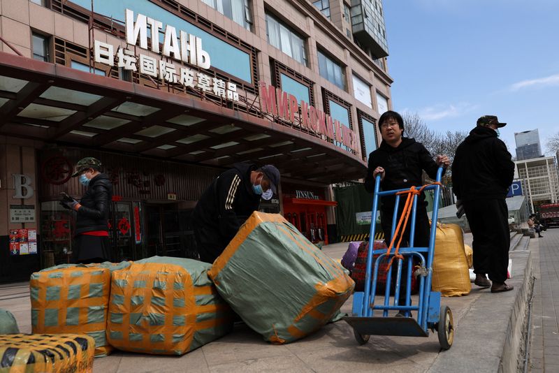 &copy; Reuters. عمال ينقلون بضائع من أجل تصديرها أمام مركز تجاري يضم متاجر ومكاتب تعرض خجمات وبضائع روسية في بكين بالصين أول أبريل نيسان 2022.تصوير: تينجشو وا