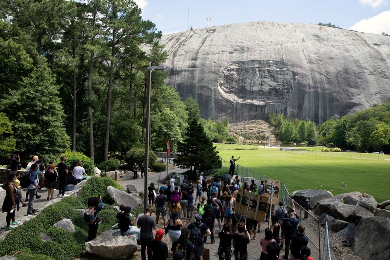 &copy; Reuters. FILE PHOTO: A man speaks into a bullhorn while pointing at the Confederate Monument carved into granite on Stone Mountain while protesting the monument at Stone Mountain Park in Stone Mountain, Georgia, U.S. June 16, 2020. REUTERS/Dustin Chambers/File Pho