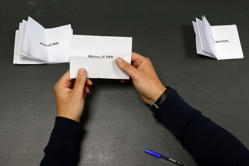 &copy; Reuters. FILE PHOTO - An official stacks ballots for Marine Le Pen, French far-right National Rally (Rassemblement National) party candidate, next to the ballots for French President Emmanuel Macron, candidate for his re-election, during counting of the votes from