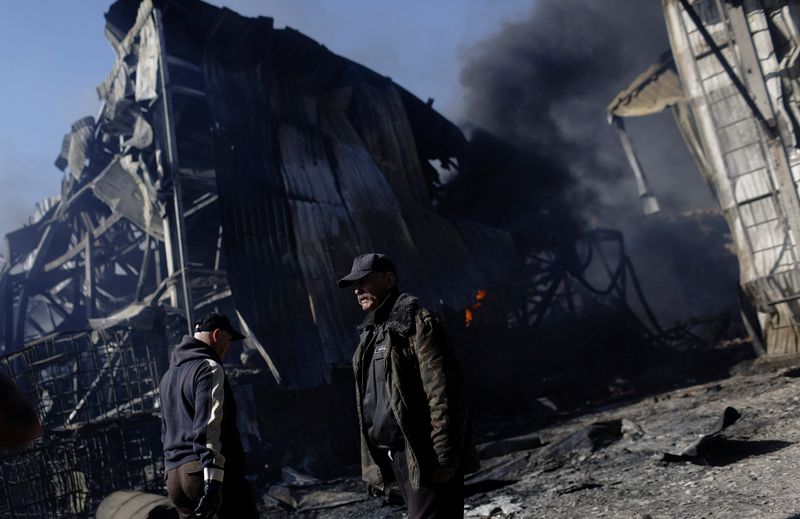 &copy; Reuters. Pessoas caminham por área danificada por disparos russos de artilharia em Kharkiv, na Ucrânia
30/04/2022 REUTERS/Ricardo Moraes