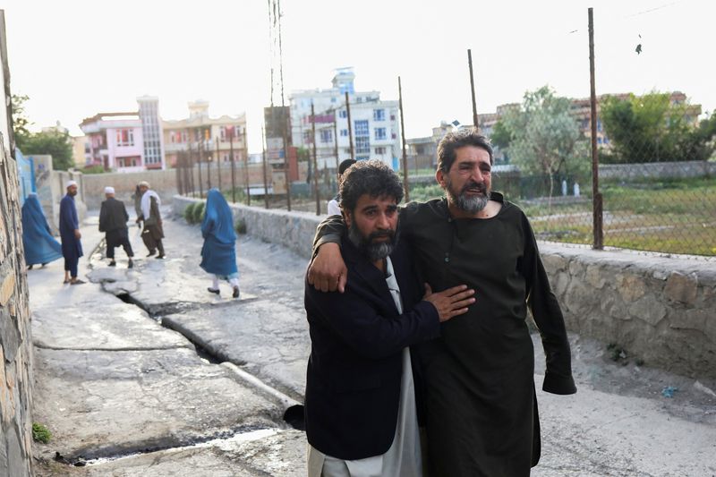 &copy; Reuters. أفغان يفرون قرب موقع تفجيرات في مسجد بالعاصمة كابول أثناء صلاة الجمعة. تصوير: علي كارا - رويترز.