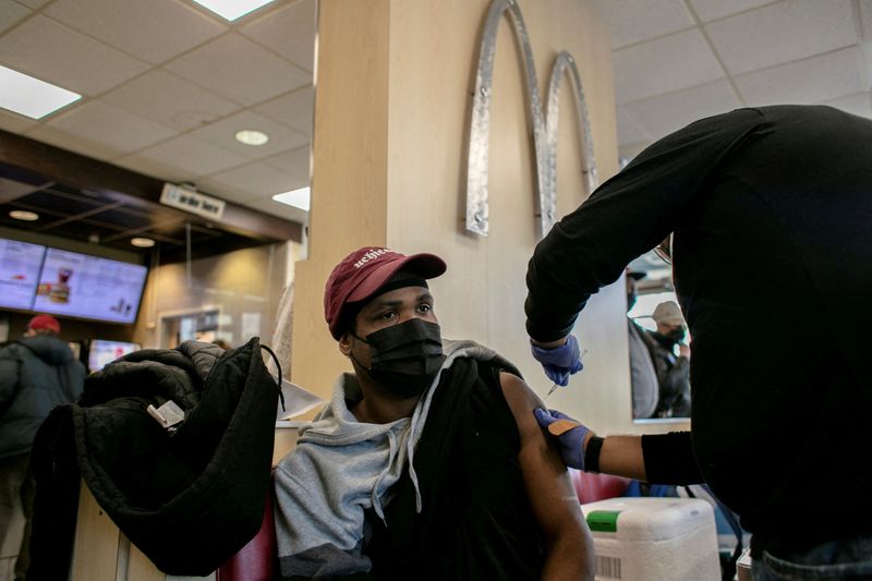 &copy; Reuters. FILE PHOTO: A man receives a booster shot for the coronavirus disease (COVID-19) at a McDonald's, as the Omicron coronavirus variant spreads through the country, in Chicago, Illinois, U.S., December 21, 2021. REUTERS/Jim Vondruska/File Photo