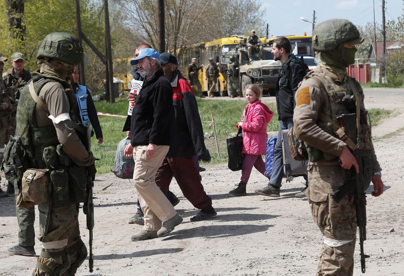 &copy; Reuters. Civilians who left the area near Azovstal steel plant in Mariupol walk accompanied by UN staff and a member of the International Committee of the Red Cross (ICRC) at a temporary accommodation centre during Ukraine-Russia conflict in the village of Bezimen