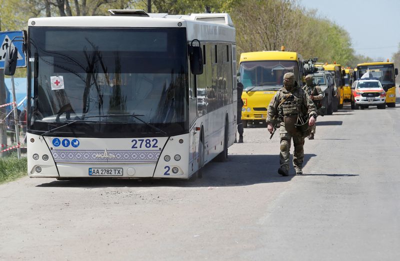 © Reuters. أفراد قوات موالية لروسيا يسيرون قرب حافلات تقل مدنيين لدى وصولها إلى قرية بيزيمين بمنطقة دونيتسك في أوكرانيا يوم الأحد. تصوير: الكسندر ايرموتشينكو-رويترز.
