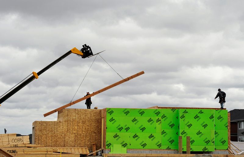 &copy; Reuters. FILE PHOTO: Construction workers are seen alongside a crane as they build homes in Calgary, Alberta, May 31, 2010.    REUTERS/Todd Korol/File Photo
