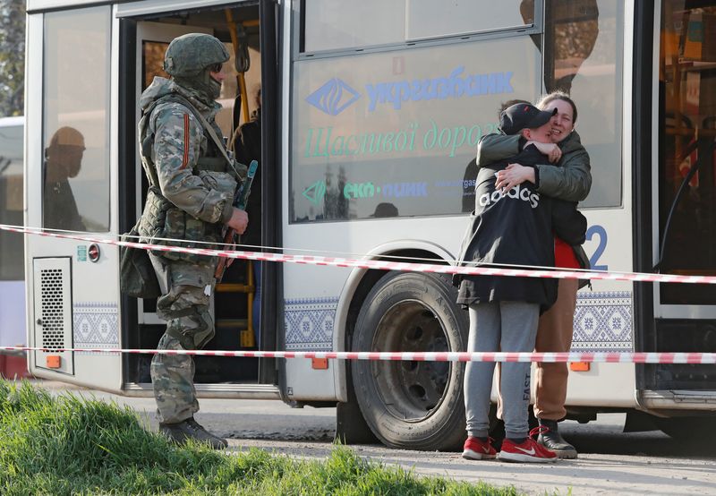 © Reuters. Une employée de l'aciérie Azovstal, évacuée de Mariupol, serre dans ses bras son fils  qui a quitté la ville avec ses proches, alors qu'ils se retrouvent dans un centre d'hébergement temporaire dans le village de Bezimenne, dans la région de Donetsk, en Ukraine. Une centaine de civils ont été évacués dimanche du site sidérurgique Azovstal à Marioupol, dans le sud-est de l'Ukraine, à la faveur d'une opération en coordination avec Kyiv, Moscou et l'Onu, a annoncé Volodimir Zelensky. /Photo prise le 1er mai 2022/REUTERS/Alexander Ermochenko