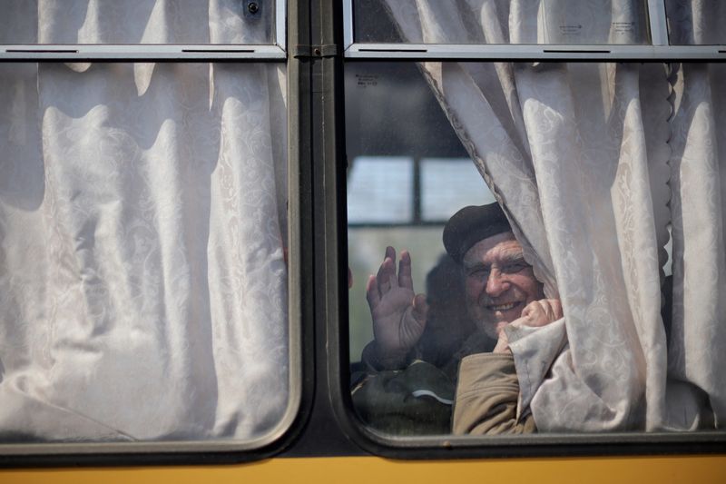 &copy; Reuters. Un refugiado ucraniano de la región de Zaporiyia saluda desde la ventanilla de un autobús tras su llegada a un centro de registro para desplazados internos por la invasión rusa de Ucrania en Zaporiyia, Ucrania, el 2 de mayo de 2022. REUTERS/Ueslei Marc