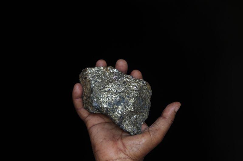 &copy; Reuters. Imagen de archivo de un minero mostrando un pedazo de mineral de cobre de las minas Kilembe, a los pies de los montes Rwenzori, Uganda.
