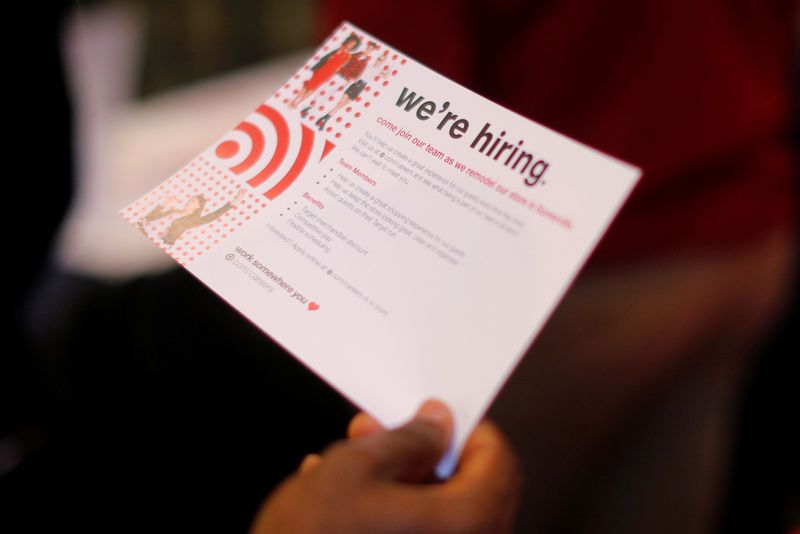 &copy; Reuters. A job seeker holds a "We're Hiring" card while talking to a representative from Target at a City of Boston Neighborhood Career Fair on May Day in Boston, Massachusetts, U.S., May 1, 2017.   REUTERS/Brian Snyder - RC114BD2E780