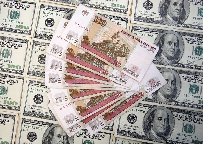 &copy; Reuters. Diverse banconote da 100 rubli sopra a banconote da 100 dollari statunitensi.  REUTERS/Dado Ruvic/
