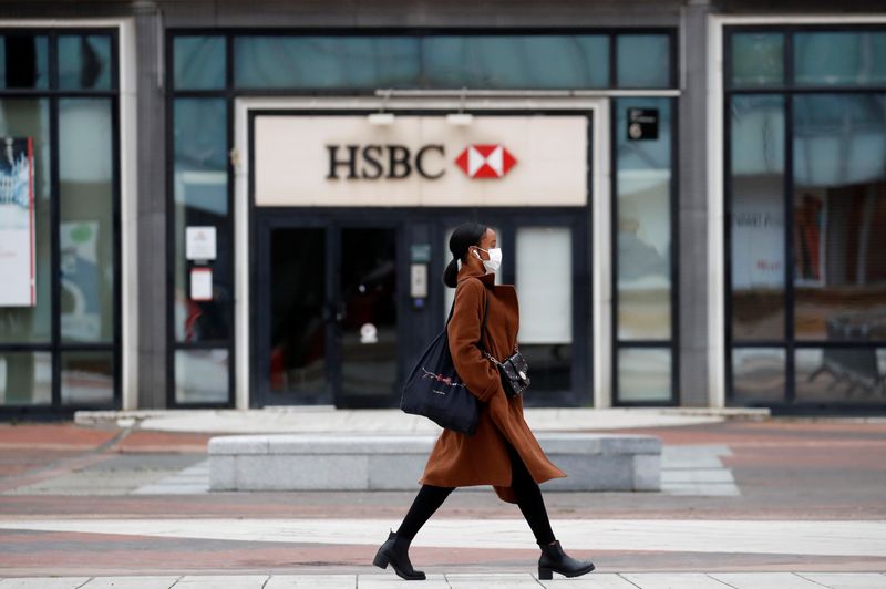 &copy; Reuters. A woman wearing a protective face mask walks past a logo of HSBC bank at the financial and business district of La Defense near Paris as France begun a gradual end to a nationwide lockdown due to the coronavirus disease (COVID-19), May 11, 2020. REUTERS/G