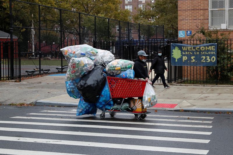 &copy; Reuters. A man with a protective face mask walks with recyclables in a shopping cart as the spread of coronavirus disease (COVID-19) continues in the borough of Brooklyn in New York, U.S., October 13, 2020. REUTERS/Shannon Stapleton/File Photo