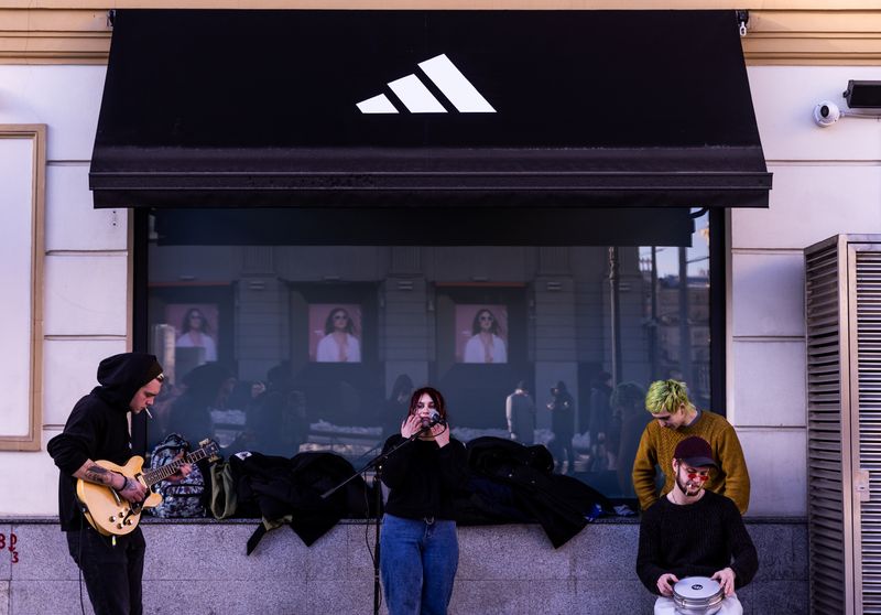 © Reuters. Street musicians play in front of a closed Adidas store in central Moscow, Russia March 15, 2022. REUTERS/Maxim Shemetov